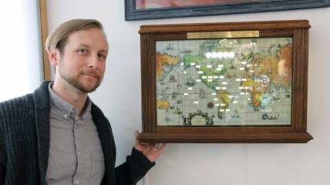 Cory Gillis next to Howard Miller world clock.