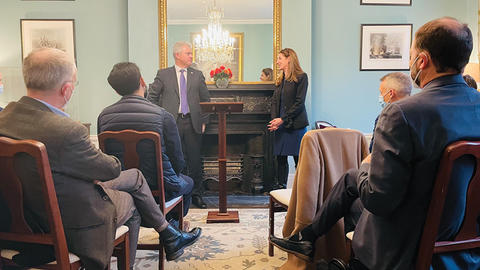 UK Secretary of State for Northern Ireland and WCFIA Director Melani Cammett look at each other at the head of the room during in-person event