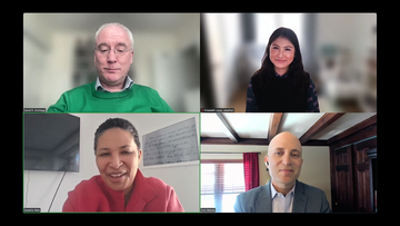 Screenshot of a virtual meeting with four people in separate video frames, each facing the camera and appearing to engage in discussion. 