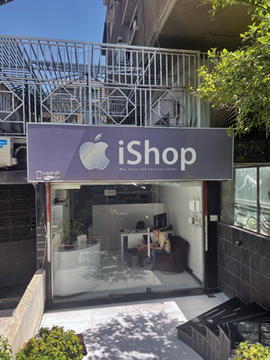 Man sits in Apple iShop store window.