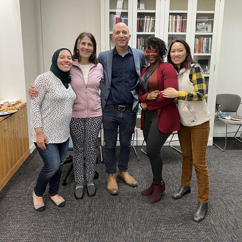 Three graduate students pose with Weatherhead director and staff.