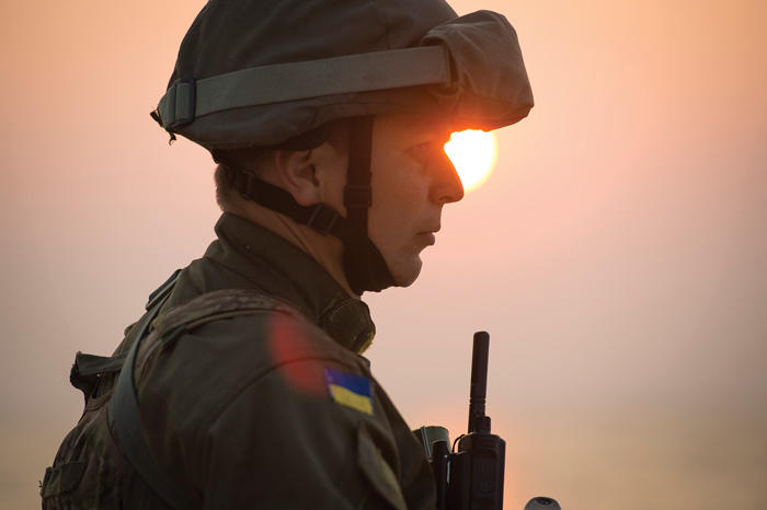 Profile of Ukrainian soldier in front of a setting sun