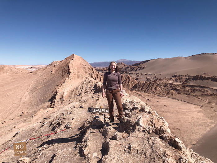 Ariel stands in the midst of the Atacama desert on a clear sunny day