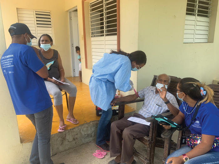 Field team members administer questionnaires and take blood samples from participants in their house