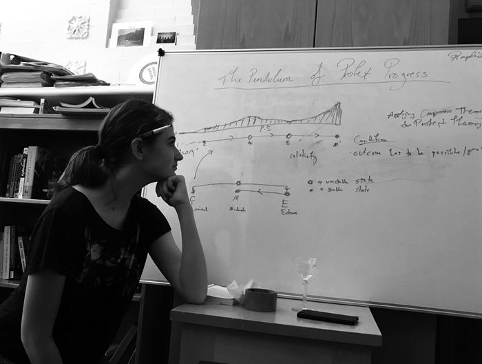 Raphaelle Soffe gazes at whiteboard drawings of her theory on protest progress
