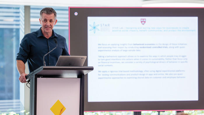 Man standing at podium with a screen behind him showing text about STAR Lab.