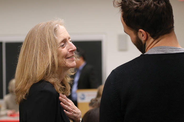 Kathy Molony talks with a colleague at the Weatherhead Forum in 2019