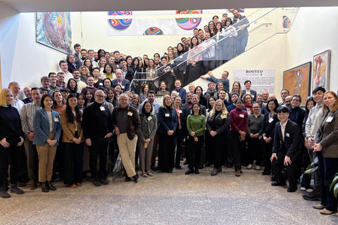 Over 100 conference-goers fill the staircase and lower floor of the basement concourse.
