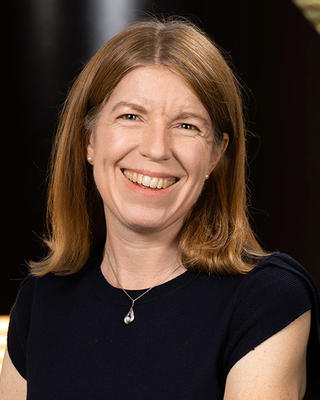 Woman with straight blonde hair smiling.