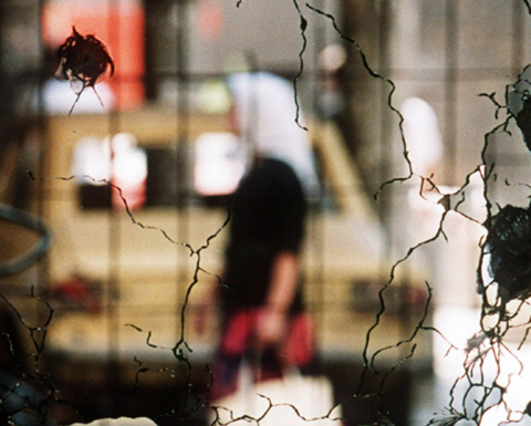 A bullet-shattered mirror in the centre of Sarejevo reflects a street scene in the summer of 1992. Credit: Mikhail Evstafiev via Wikimedia Commons
