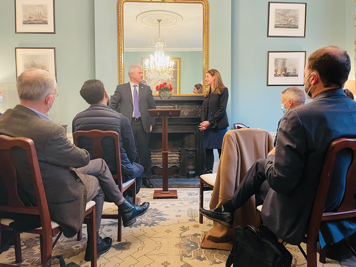 UK Secretary of State for Northern Ireland and WCFIA Director Melani Cammett look at each other at the head of the room during in-person event