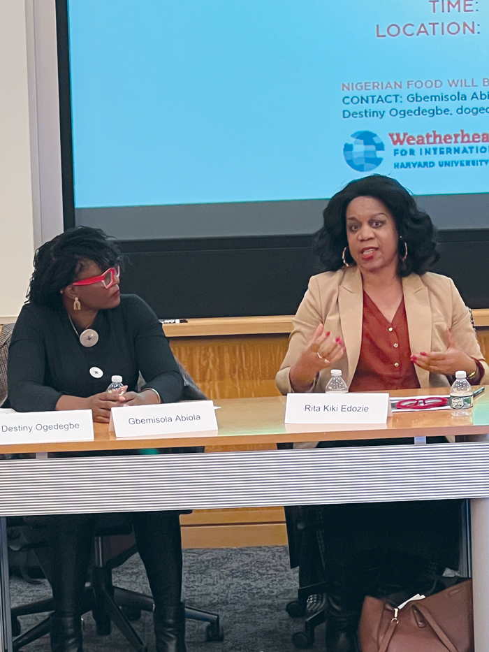 Gbemisola Abiola and Rita Kiki Edozie seated at a table and presenting on the Uganda elections.