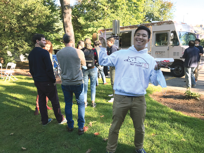 Harvard student Jonathan Zhang poses in front of the waffle truck