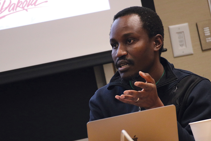Scholars Program Fellow discusses research in front of his slide show at a Scholars Program seminar